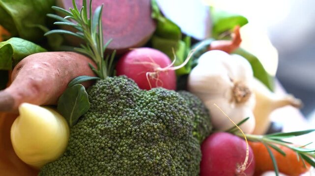 Collection of organic vegetables, bundled together, for sale in market, panning close up.