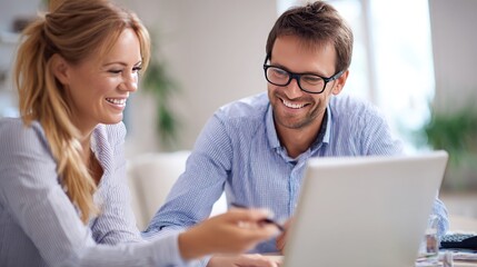 Obraz premium Happy young businessman in formalwear working with female colleague in office. Smiling businessman looking at camera, talking with colleague. Teamwork concept