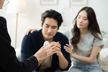 Couple seated across therapist in counseling session, husband shows signs of burnout and workplace failure, receiving psychological support, working through depression, emotional care and advice