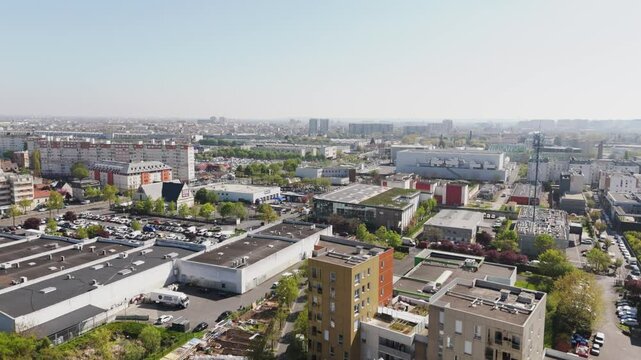 Drone advances over Franconville showing buildings and rooftops in the Paris suburban landscape - France
