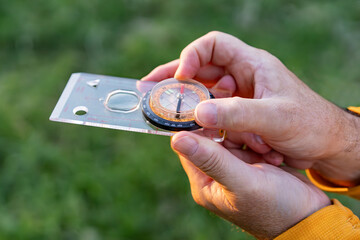 Close-up of a man with compass exploring natural environment