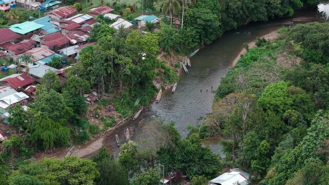 Tight shot of wooden sampan lined on muddy banks of Sungai Bayung, Upper Baram at Long Lamai village.