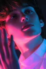 A close-up portrait of a young model with dramatic neon lighting, highlighting the soft features of the face. The combination of pink and blue light creates a bold, artistic effect.