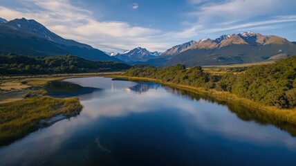 Fototapeta premium Aerial Shot of a Crystal Clear Lake Reflecting Surrounding Mountains and Blue Sky