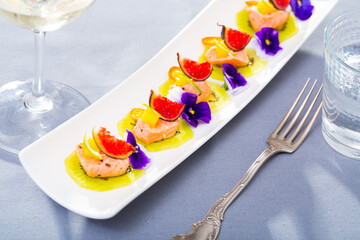 Close up of tasty seafood ceviche from salmon with figs, kiwi and cumquat