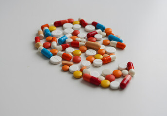 Colorful pills arranged on white surface for health and medical concepts