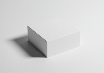 A simple white cube box sits on a white surface casting a soft shadow in a minimal style