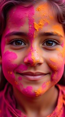 Obraz premium A young girls face is adorned with vibrant pink and orange Holi powder, a joyful expression illuminating her features. The colors are richly textured, creating a captivating visual.