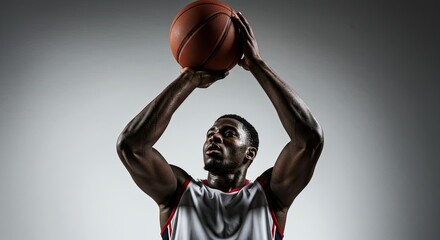 Focused African American basketball player shooting the ball in studio