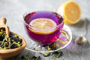 Blue tea Anchan or Butterfly pea in glass cup with dry flower of clitoria. Purple tea with lemon. Asian drink