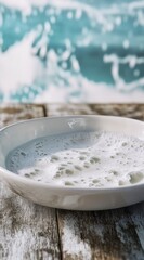Foamy liquid in a white bowl near ocean