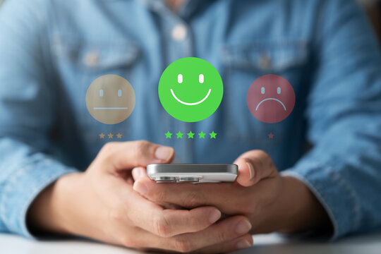 Customer experience rating concept showing hand holding smartphone with positive feedback emoji, satisfaction level, and review system for business or service analysis.