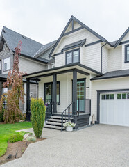 Fototapeta premium Entrance of grey painted luxury house in spring with stair steps and nice landscape in Vancouver, Canada, North America. Day time on April 2025.