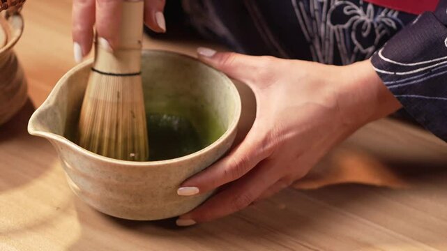 Traditional Japanese kimono is brewing macha green tea for ceremony, evoking a warm cultural ambiance.