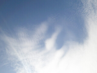 Calm blue sky with layered altostratus clouds, creating a tranquil and atmospheric view