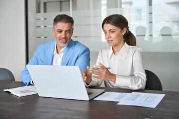Two busy professional executives team business people working together on computer at office...