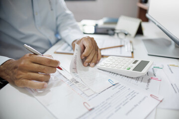 accountants working on desk checking receipts and expenses and calculate business costs, profits...