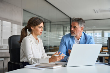 Professional manager consulting corporate client using laptop. Two busy professional executive team...
