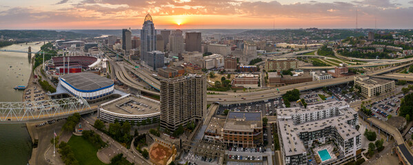 Naklejka premium Downtown district of Cincinnati in Ohio, USA at sunset with brightly illuminated high skyscraper buildings. American travel destination