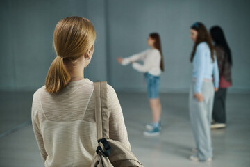 Group of young dancers practicing in studio while one person in foreground observing the rehearsal. Diverse group engaged in preparing dance routine in modern studio