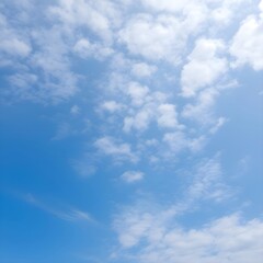 Obraz premium Background with scattered white clouds in bright blue sky creating a serene atmosphere