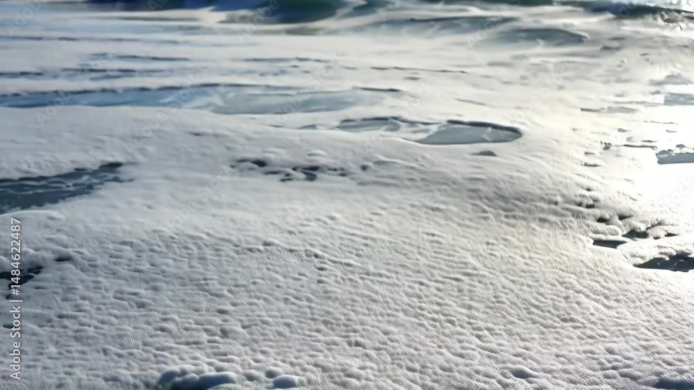Poster white sea foam covering ocean surface in a sunny day, creating a unique abstract texture with light 