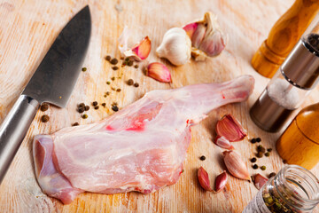Raw young hogget shoulders on wooden surface with seasonings. Main ingredient for cooking