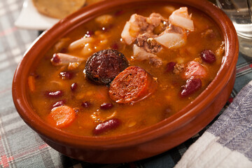 Traditional dish of Asturian cuisine - beans stewed with pork, blood sausage and chorizo (Fabada) served in clayware..