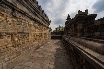 Fototapeta premium Statues and carvings made of volcanic rock at Borobudur Temple in Yogyakarta, Java, Indonesia. The largest temple in the world, one of the most visited monuments in the country.