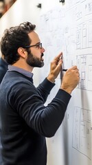 Architect brainstorming on whiteboard with sketches