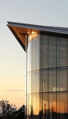 Fototapeta premium Modern Glass Building Exterior, Architectural Detail with Geometric Design, Sunset in Background