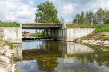 Fototapeta premium Concrete flood control bridge over river with weir