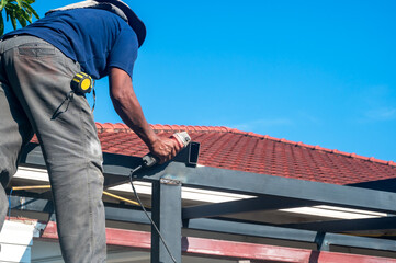 Roofer man installing house roof in construction site