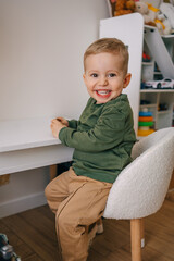 Happy young child smiling while seated at home in a playful environment