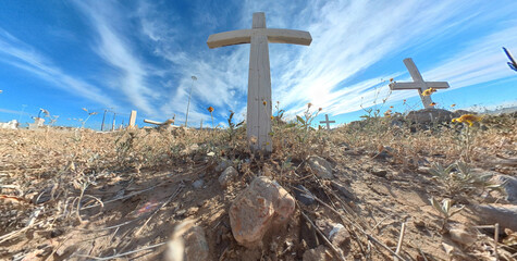 Wooden cross at cemetery with stripped sky background