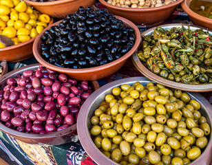 A colorful display of Moroccan olives in bowls with preserved lemons and herbs