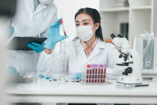 Medical research team conducting health and pharmaceutical experiments using blood samples in laboratory to develop advanced treatments and vaccines for global healthcare innovation