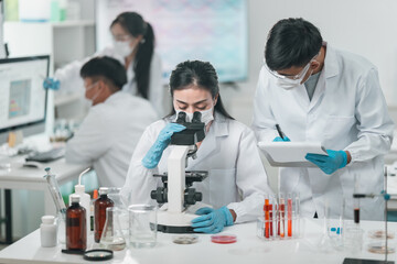 Medical research team conducting scientific experiments in a pharmaceutical laboratory, analyzing...