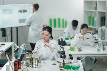 Medical science research team in modern laboratory conducting experiments, analyzing samples under...