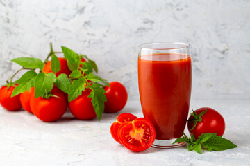 Tomato juice in a glass and fresh tomatoes
