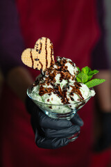 Handmade ice cream cup held by person with black gloves