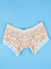 beige lace briefs on a blue background. concept love between women
