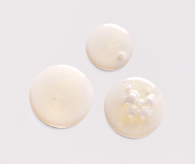 round drops of serum gel texture cosmetic products on light background