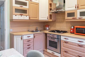 wooden built-in cupboards in kitchen. Brown furniture in kitchen. Bright kitchen furniture design....