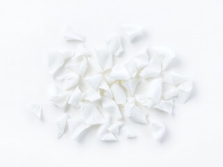 Delicate white flower petals scattered on a clean white surface providing elegant aesthetics