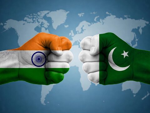 clenched fists painted with India and Pakistan flags facing each other, symbolizing rivalry, tension, or competition between the two nations against a global map background.
