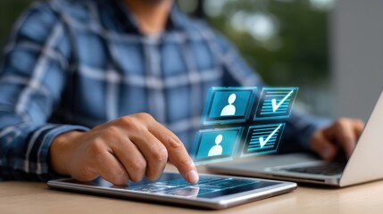 A person using a tablet and laptop for digital management and communication tasks.