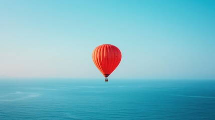 Obraz premium Red hot air balloon floats over tranquil ocean