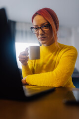 Focused freelancer working remotely and enjoying a cup of coffee