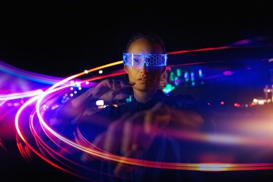 Asian woman in Futuristic High-tech VR Eyewear in night city. Ar
